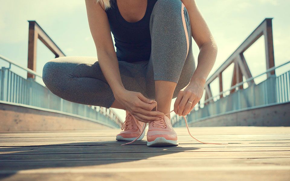 Blonde Frau bindet sich die Schuhe